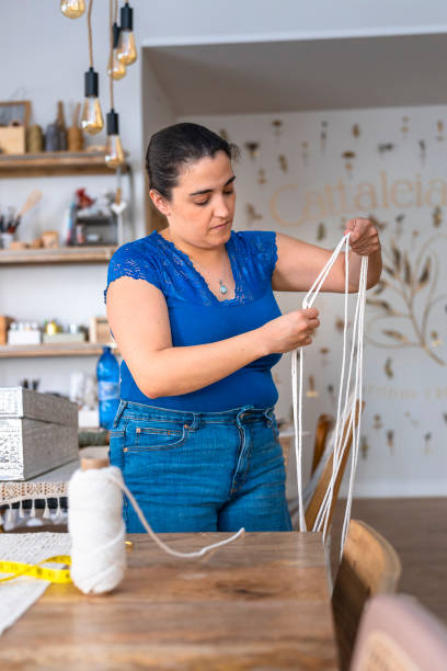 istock Middle-aged woman works in a sewing workshop 1590215483