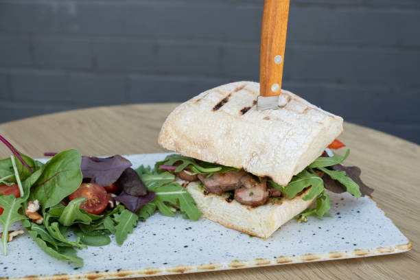 istock Burger with meat and vegetables on wooden table 1590220984