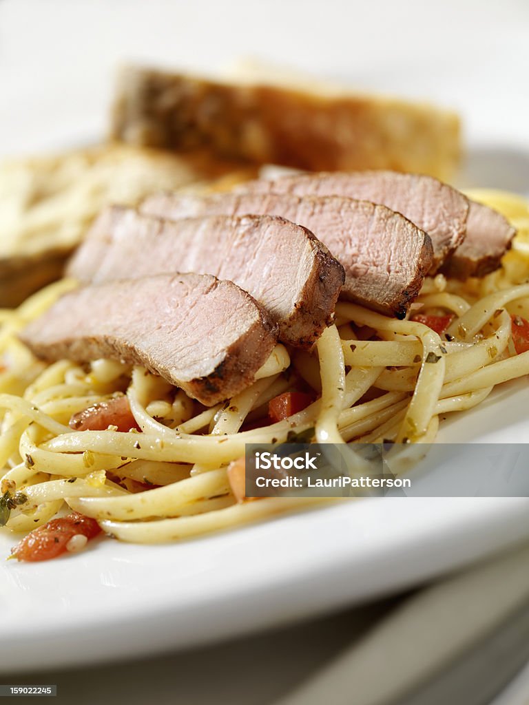 Strip Steak con pomodoro e Linguine alle erbe - Foto stock royalty-free di Al sangue