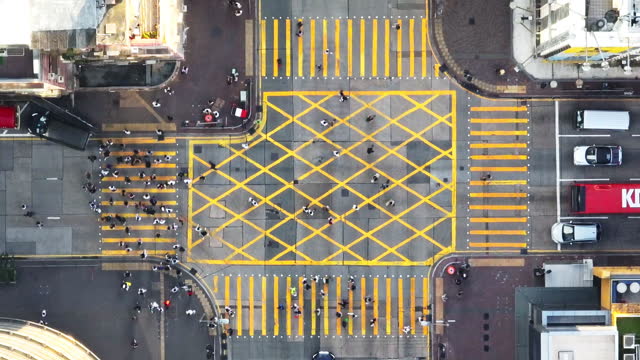 Car traffic transport on road, pedestrian people walk cross zebra crossing, crossroad junction in Mong Kok, Hong Kong downtown. Drone aerial top view. Asian lifestyle, Asia transportation city life