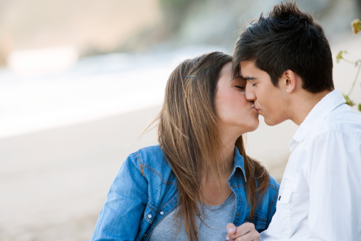 Close up portrait of romantic kiss on beach.