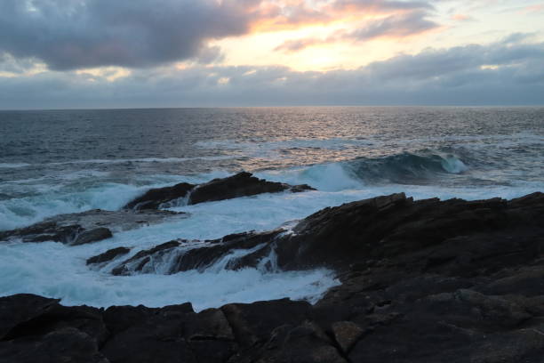 istock Waves crashing on the rocks 1590294293