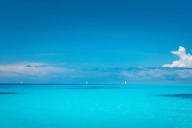 Bright tropical turquoise sea under a blue sky with white boats on the horizon in Zanzibar