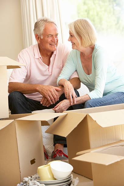 istock Senior Couple Moving Into New Home Surrounded By Packing Boxes 159030564
