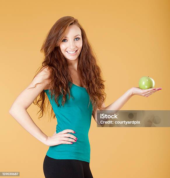 Foto de Jovem Garota Segurando Uma Maçã Verde e mais fotos de stock de 20 Anos - 20 Anos, Adulto, Alegria