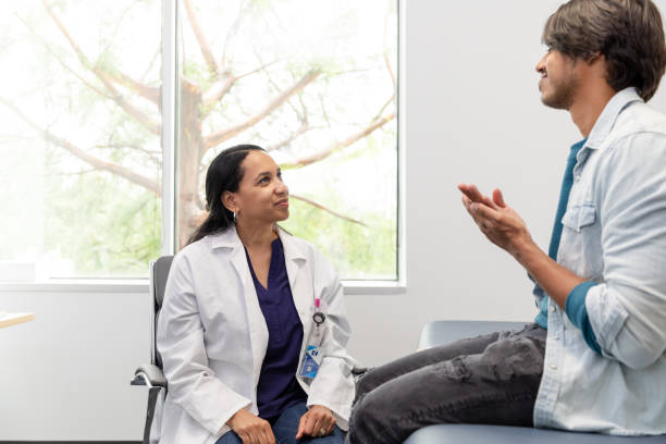 istock Man uses sign language to talk about symptoms with doctor 1590331771