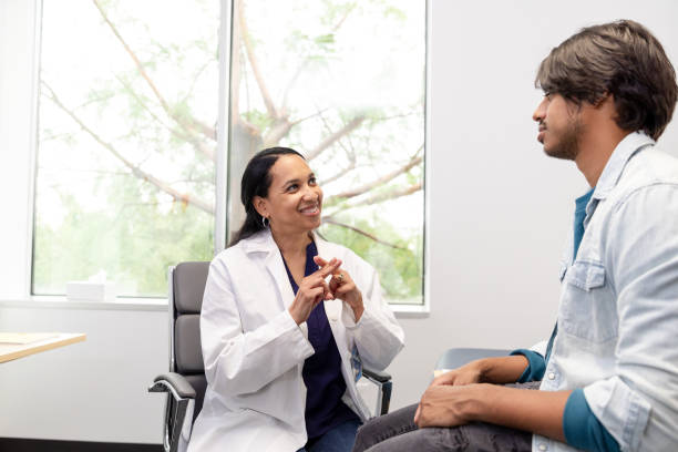 istock Female doctor smiles while using sign language with patient 1590331786