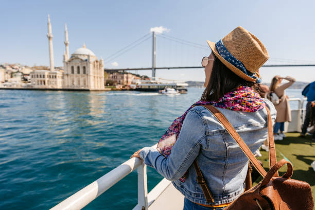 mujer disfrutando de la vista de la mezquita ortakoy y el puente de los mártires del 15 de julio en estambul - ortakoy mosque bridge bosphorus istanbul fotografías e imágenes de stock