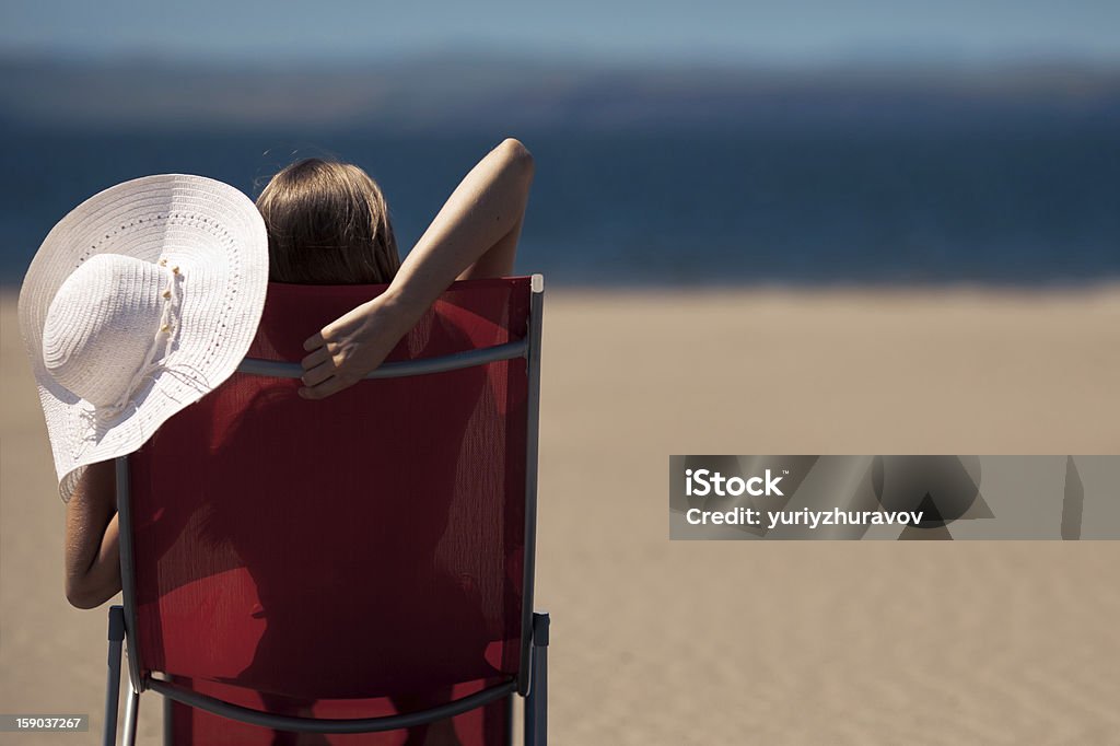 Женщина, лежа на deckchair на пляже - Стоковые фото Бежевый роялти-фри