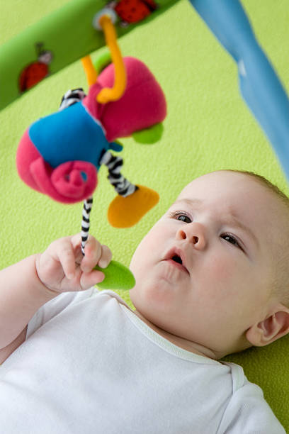 istock Baby boy lying on blanket grabbing toy, elevated view 159037529