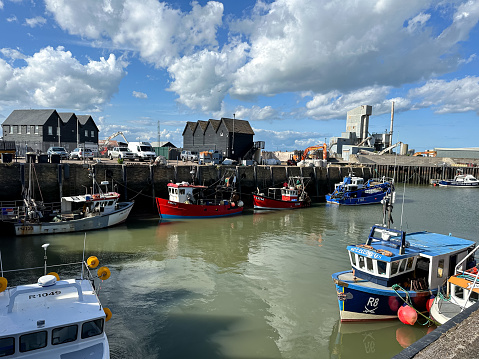 Fishing boats moored at Whitstable harbor in Kent England. Sunny day in Whitstable