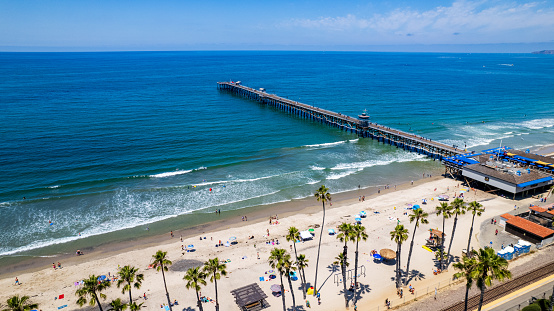 Ariel view of San Clemente beach and pier on a summer day filled with beach goers and tourist