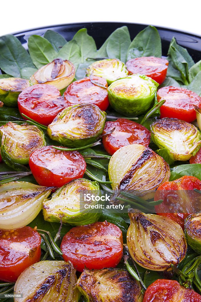 Roasted vegetables Roasted vegetables on leaves of green spinach. Photo close-up. Appetizer Stock Photo