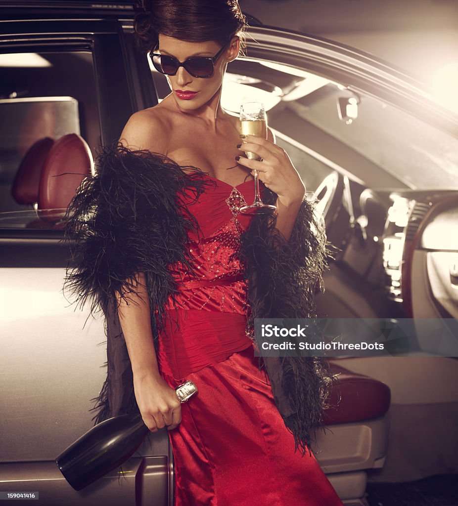 Triste femme glamour debout près de voiture de luxe avec du Champagne - Photo de Champagne libre de droits