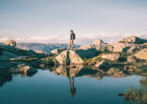 man on the shore of a mountain lake in Norway