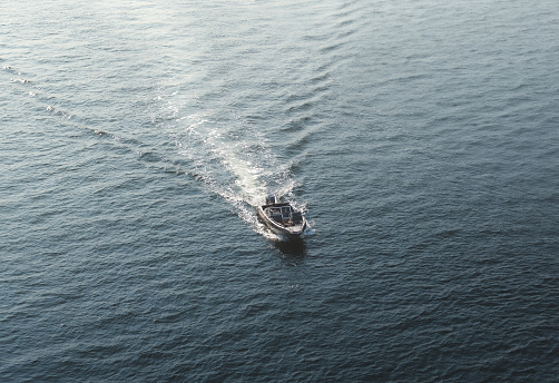 Aerial view of a small motor boat sailing in the sea