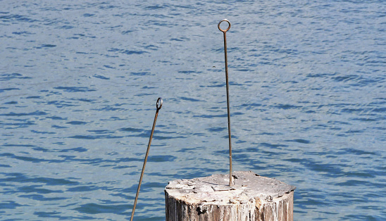 Metal anchor stakes in a  wooden pole at Stearns Wharf in Santa Barbara, California, USA.