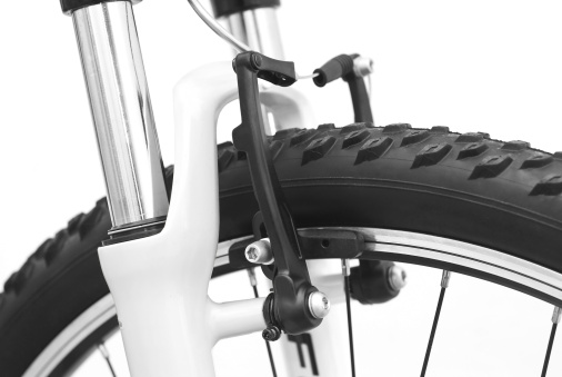 Close-up of the handlebar of an old vintage dutch bike with brake handle and bicycle gear lever for a classical 3-speed gear hub, front light and bike bell.