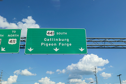 Pigeon Forge, Tennessee, USA - July 31, 2023: A directional street sign in Gatlinburg and Pigeon Forge Tennessee on the Parkway