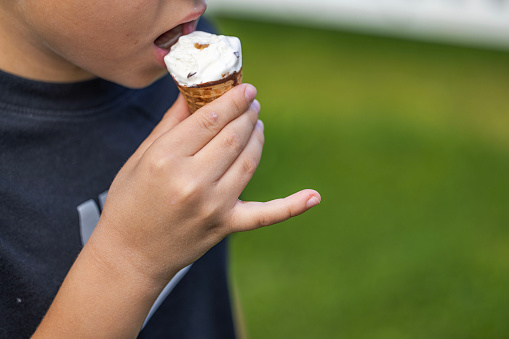 Close-up view of boy eating ice cream in garden. Sweden.