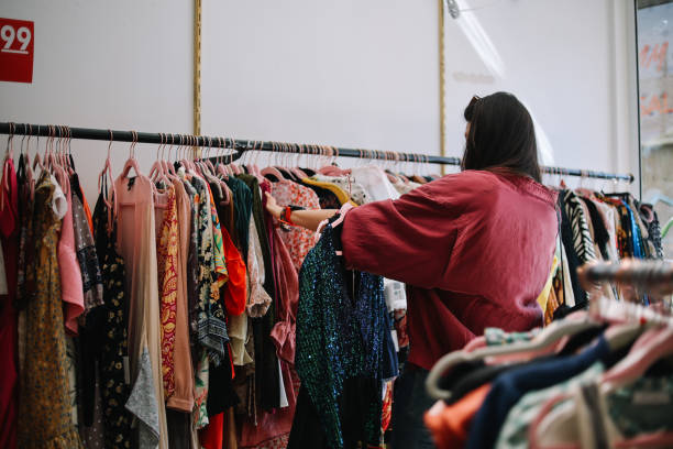 femme à la recherche de vêtements à los angeles, californie - dépôt vente photos et images de collection