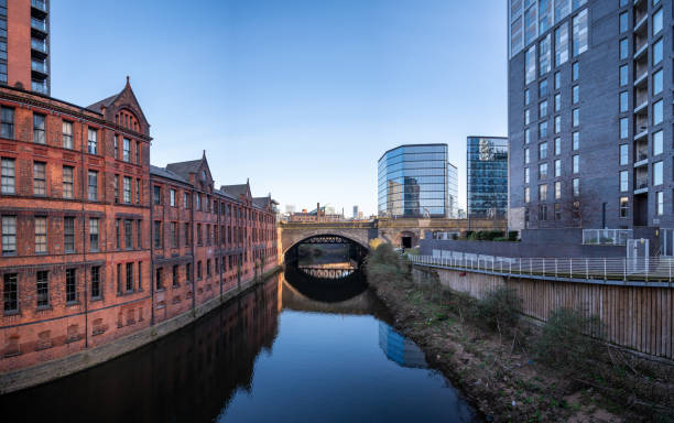 Historic inner city canal conservation area with an arched bridge  in Manchester, UK.