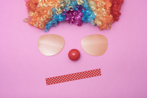 Funny Party concept face formed with glasses lens. Rainbow Clown Wig Set and red clown nose like a face, Fluffy Afro Synthetic Cosplay Anime Fancy Wigs Festive Background