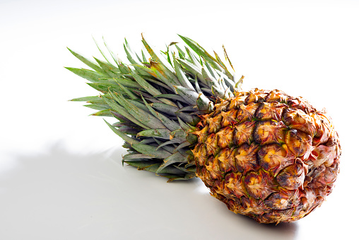 Pineapple lying on white background. Exotic tropical fruit on white color background