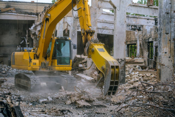 istock Steel hydraulic attachment pliers on excavator grappling construction debris in collapsed industrial building 1590576293