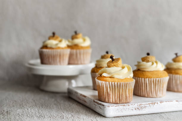 istock Group of pumpkin stuffed cupcakes with cream cheese frosting front view 1590588529