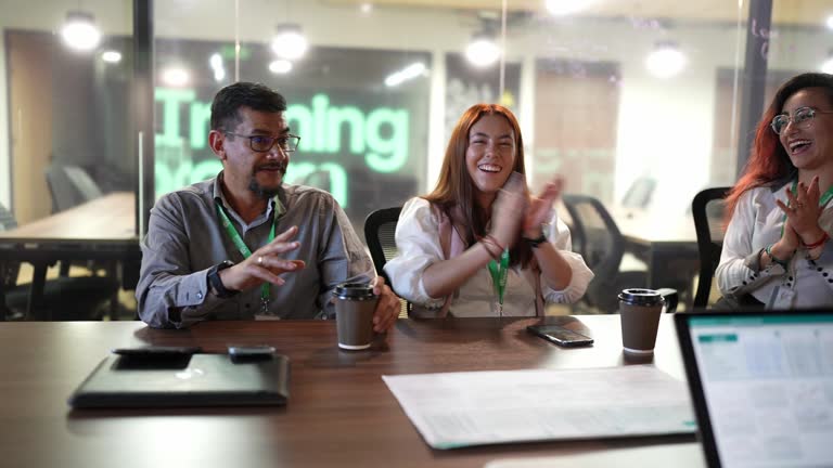 Coworkers applauding presentation in the meeting room