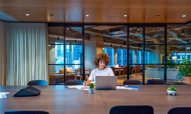 Young woman working on a laptop computer in a modern office.
