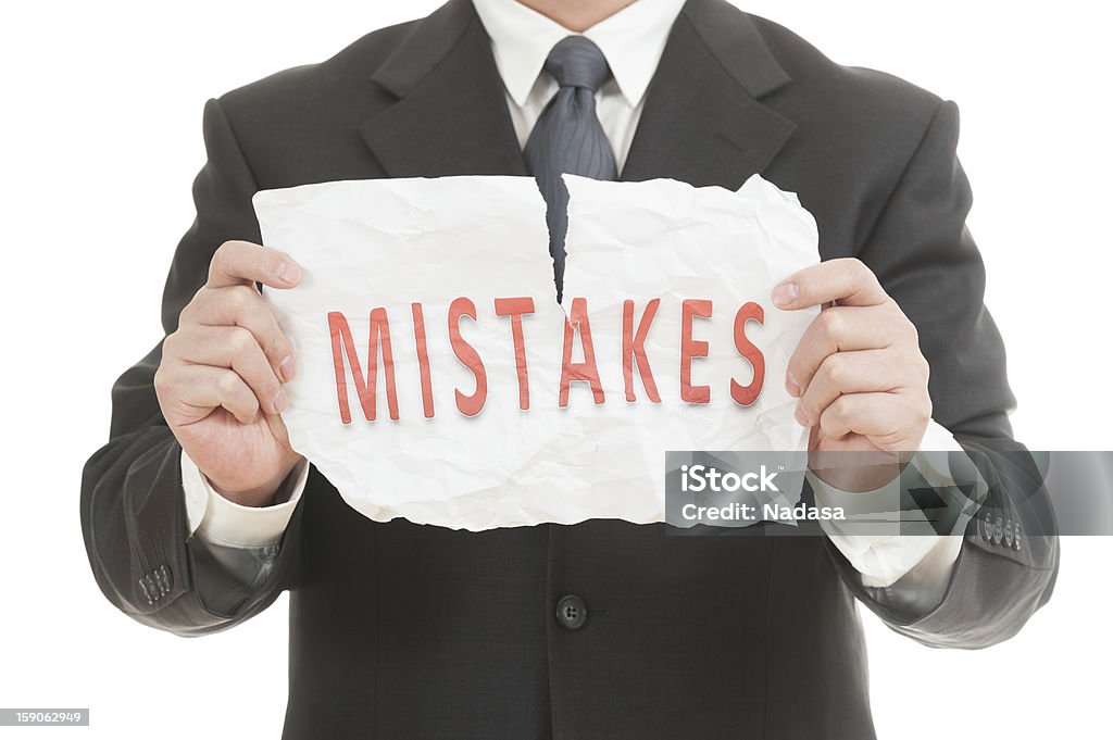 Tearing mistakes word Businessman tearing paper which written mistakes word Adult Stock Photo