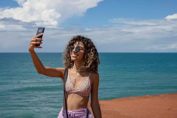istock Young woman making selfie on beautiful beach 1590635796
