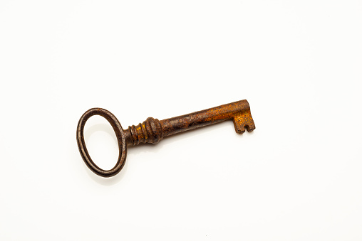 High angle view of old rusty style key on white background.