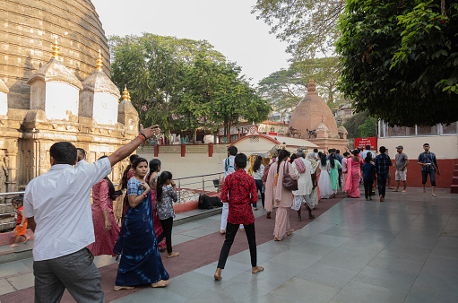 Guwahati, India - 10th April 2023: A Guide points his group in the correct diretion for Kamakhya Temple in Guwahati, Assam, India. Kamakhya Mandir is a very important centre for Tantric  worship in the Hindu tradition.