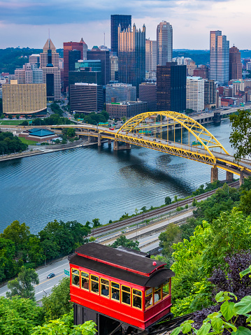 Red car of Duquesne Incline with Pittsburgh downtown panorama on background at sunset