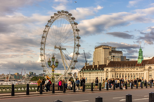 Tourists on Westminster Bridge with London eye in the background. Shot 25 July 2023.