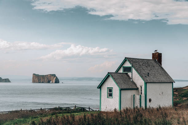 July 24, 2023, sunny day. Bonaventure Island, Gaspe peninsula, Quebec, Canada. The small houses on Bonaventure Island and the perce rock on the sea in the distance made a beautiful picture.