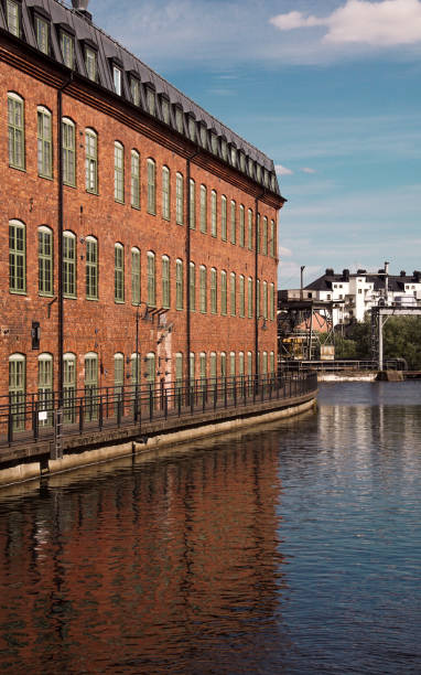 istock View of buildings by river against cloudy sky 1590827375