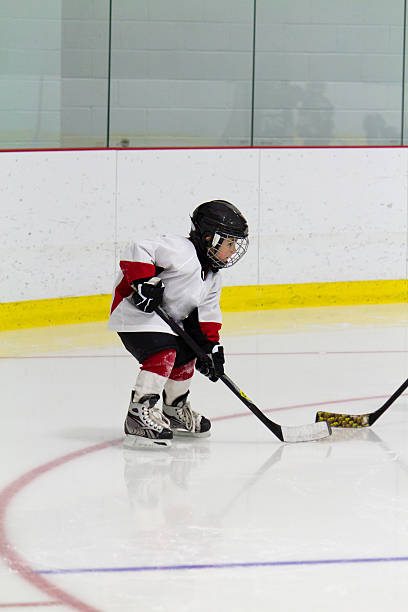 Little boy playing ice hockey stock photo