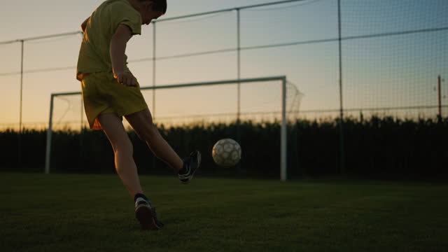 SLO MO Male Soccer Player Dribbles on the Grass Field and Shoots the Goal at Sunset