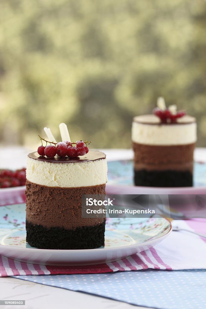 Tripple chocolate mousse cakes Tripple chocolate mousse mini cakes, garnished with redcurrant Bakery Stock Photo