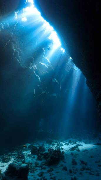 istock Rays of sunlight in a cave underwater 1590898075