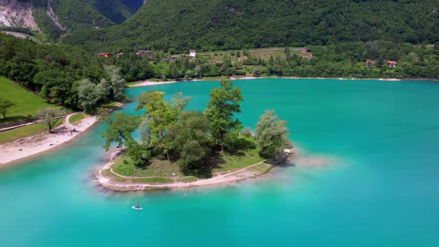 Amazing beautiful turquoise lake Tenno in Trentino region of Italy, surrouded by Alps mountains. aerial drone video with tiny island