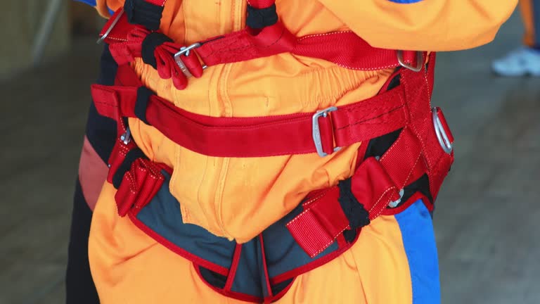 Practicing instructor checks the equipment before the tandem jump, tightens the straps.