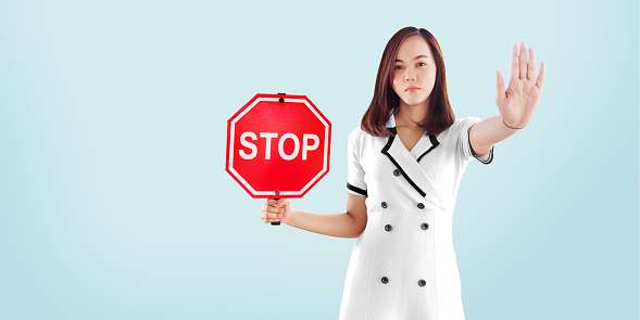 asian woman show stop sign to abuse and present disagree on bullying, diverse, gender discrimination or female violence concept. model present on banner size and copy space for text