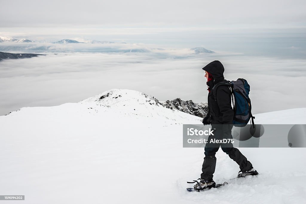 Mulher caminhadas com raqueta de neve nas montanhas - Foto de stock de 25-30 Anos royalty-free