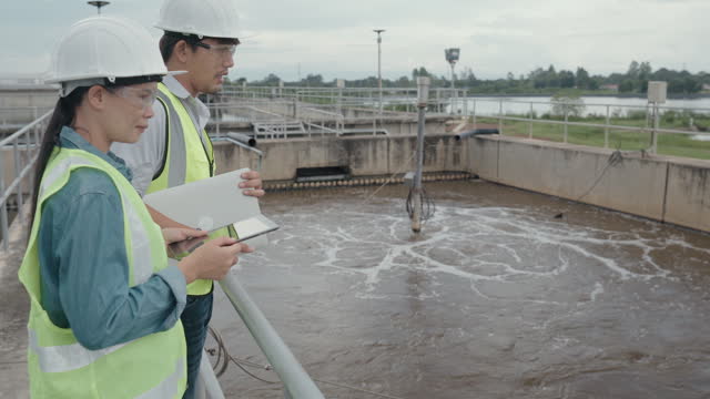 Two Environmental engineers work at wastewater treatment plants,Water management concept.