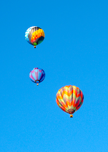 istock Colorful three hot air balloons on blue sky. Space for text. 1591064362